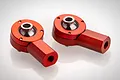 Two red anodized aluminium ball end joints for RC suspension arms, featuring a spherical bearing and threaded shaft.