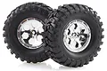 Two black rubber RC crawler tyres mounted on shiny chrome-plated six-spoke wheels against a white background.