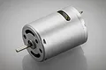 A silver-coloured brushed electric motor for RC vehicles, shown from a three-quarter angle against a grey background.