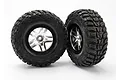 Two Traxxas 2.2/3.0 inch Kumho Road Venture MT tyres pre-mounted on satin chrome and black wheels against a white background.