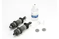 Two grey composite Traxxas GTR shock bodies, a bottle of silicone oil, and small plastic shock components on a white background.