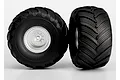 Two Traxxas Terra Groove RC monster truck tires mounted on satin chrome wheels, shown from front and side angles against a white background.