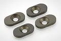 Four dark grey, oval-shaped metal engine mount inserts with countersunk center holes, arranged on a white background.
