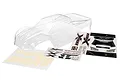 Clear, unpainted Traxxas X-Maxx RC truck body shell with included decal sheets and window masks on a white background.
