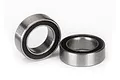 Two small metal ball bearings with black rubber seals sitting on a white background.
