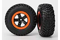 Two Traxxas RC short course wheels with black rubber tyres and black and orange rims against a white background.