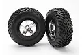 Two Traxxas 2.2/3.0 inch off-road tires pre-mounted on satin chrome and black wheels against a white background.