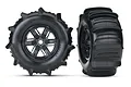 Two Traxxas X-Maxx paddle tires mounted on black multi-spoke rims, shown from front and side angles against a white background.