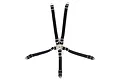 A 1/10 scale black five-point racing harness seat belt accessory with silver buckles and mounting tabs on a white background.
