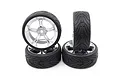 Four RC car wheels with silver five-spoke rims and black treaded rubber tyres arranged in a stack against a white background.