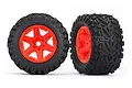 Two Traxxas 3.8 inch Talon EXT RC monster truck tyres pre-glued onto bright orange six-spoke plastic rims against a white background.