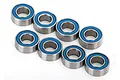 Eight small metal ball bearings with blue rubber seals arranged on a white background.