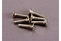 A small pile of six silver-coloured metal countersunk screws with coarse threads on a grey surface.