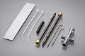 Tamiya Grasshopper rod set including metal rods, zip ties, a rubber tube, and a cross wrench tool on a grey background.