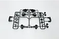 A Tamiya plastic parts tree containing black molded RC components including hubs, wheel hexes, and servo horns on a white background.