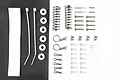 A Tamiya parts bag containing various RC hardware including shock springs, screws, body clips, zip ties, and spacers arranged on a split black and white background.