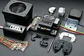 Tamiya MFC-03 Multi-Function Control Unit kit components including a speaker, control box, wiring harness with LEDs, and various mounting brackets.