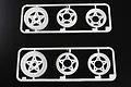 Two identical white plastic sprues each containing three five-spoke RC buggy wheels against a black background.