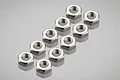 A set of ten small silver-colored metal hex nuts arranged in two rows on a reflective grey surface.