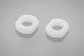 Two white plastic shock pistons for Tamiya RC cars shown against a neutral grey background.