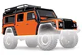 Orange Traxxas TRX-4 Land Rover Defender body shell with black roof rack and accessories, shown on a faded chassis background.