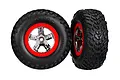 Two Traxxas 2.2/3.0 inch off-road tyres pre-mounted on chrome and red five-spoke wheels against a white background.