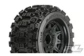 A close-up studio shot of a Pro-Line Badlands MX28 tyre mounted on a black Raid wheel, showing the aggressive tread pattern and wheel details.