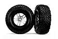 Two Traxxas 2.2/3.0 inch off-road tires pre-mounted on satin chrome and black wheels against a white background.