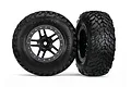 Two Traxxas 2.2/3.0 inch off-road RC wheels with black multi-spoke rims and satin chrome beadlock-style rings, shown against a white background.
