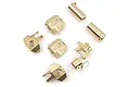 A collection of brass RC upgrade parts including differential covers, steering knuckles, and axle tubes on a white background.