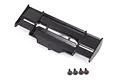 A black plastic RC car wing for the Traxxas Rustler 4x4, shown from a top-down angle with four included mounting screws below it.
