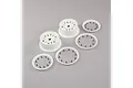 Two white RC car wheel rims and three white beadlock rings with black screws arranged on a grey background.