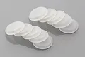 A set of ten translucent white rubber shock cap seals for RC vehicles arranged in two stacks on a grey background.