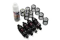 A set of four black aluminium RC shock absorbers with extra springs and a bottle of Yeah Racing silicone damper oil on a white background.