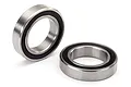 Two Traxxas rubber-shielded ball bearings shown on a white background, one standing upright and one lying flat.