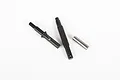 Axial Capra Dig Transmission Shaft Set including two black metal shafts and one silver metal pin on a white background.