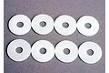 Eight white circular plastic body shell washers arranged in two rows of four on a grey surface.