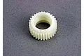 A white plastic 30-tooth idler gear for Traxxas RC vehicles shown from a top-down angle on a grey textured surface.