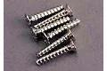 A group of six silver-coloured metal countersunk head screws with coarse threads arranged on a grey surface.