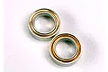 Two small metal ball bearings with gold-coloured shields on a white background.