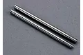 Two silver metal RC shock shafts with threaded ends and grooves for clips, laid side-by-side on a grey textured surface.