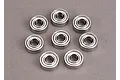 Eight small metal shielded ball bearings arranged in a circular pattern on a grey background.