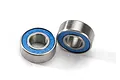 Two Traxxas rubber-shielded ball bearings with blue seals and silver metal outer rings on a white background.