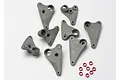 A set of grey plastic Traxxas progressive rocker arms and small red aluminium spacers arranged on a white background.