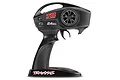 A black Traxxas TQ 2.4GHz 2-channel pistol-grip RC transmitter with a steering wheel and throttle trigger on a white background.