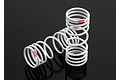 Two white Traxxas RC shock springs with pink identification markings on a black reflective surface.
