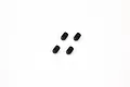 Four small black metal grub screws arranged in a square pattern on a white background.