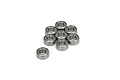 A set of eight small silver metal ball bearings arranged in a cluster on a white background.