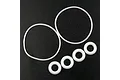 A set of six white O-rings of varying sizes arranged on a black textured surface.