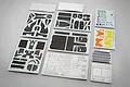 A collection of detail-up parts for a 1/20 scale NuNu McLaren MP4/2C model kit, including carbon fiber decals, metal photo-etched parts, and stickers.